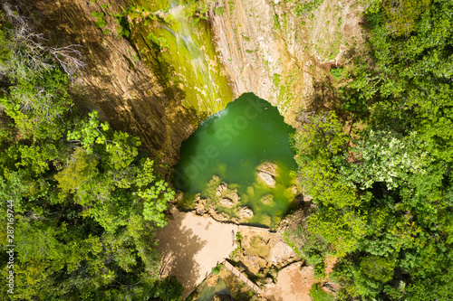 Scenic aerial view of El Limon waterfall in jungles of Samana peninsula in Dominican Republic. Amazing summer look of cascade in tropical forest from above close up.