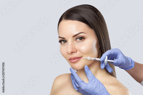 There is a woman, who is making the Lips augmentation procedure in a beauty salon.Cosmetology skin care.