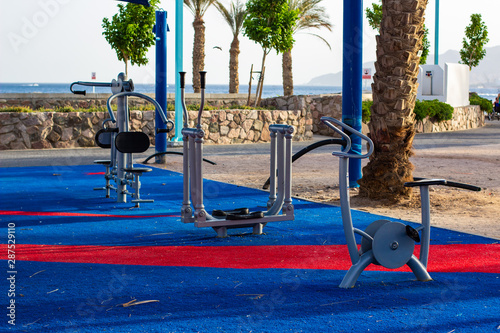 urban square district training apparatus for sport activities on waterfront shoreline near sea with palm trees background
