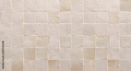 Old retro beige ceramic tile texture background. Beige square tiled wall.