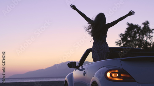 Young Woman in Cabriolet at Sunset