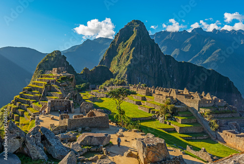 The majestic Machu Picchu at sunset with the last tourists in the lost city of the Inca, Cusco region, Peru.