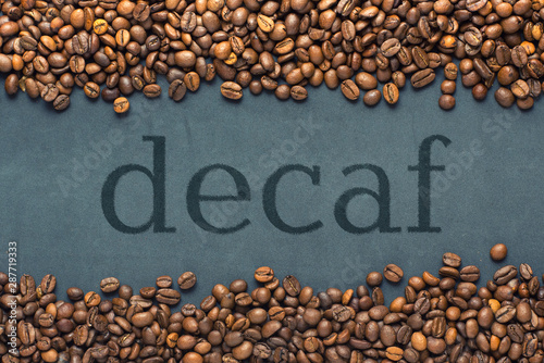 Closeup of coffee beans on grey background with the inscription decaf