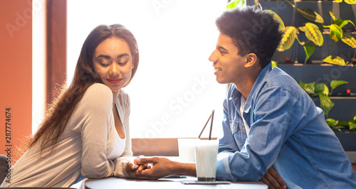 Black guy telling good words his flattered girlfriend