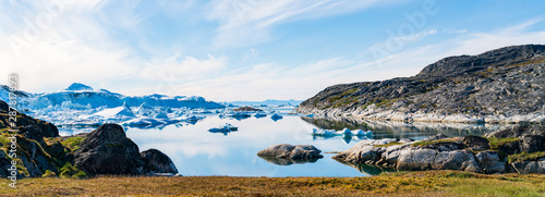 Greenland arctic nature landscape with icebergs in Ilulissat icefjord. Panoramic banner photo of scenery ice and iceberg in Greenland in summer.