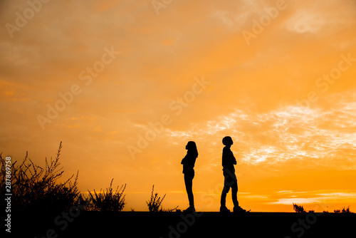 Break Up, Bad relationship, Anger, unhappy, concept. Silhouette of anger of couples love who are quarreling (argument) and standing back to back with sunset background in Thailand