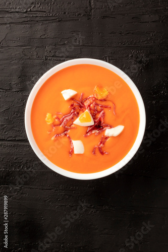Salmorejo, Spanish chilled tomato soup, shot from the top on a black background with copyspace
