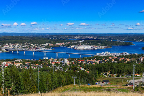 Sundsvall, Sweden, A view over the city from a local mountaintop and a paper mill in the foreground.