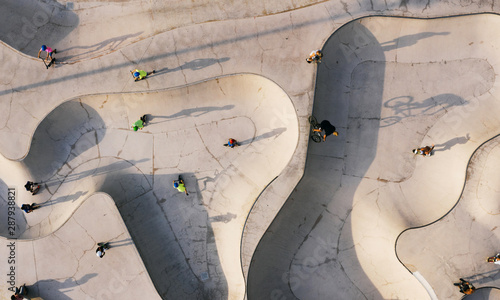 Skate park top view. Young people doing sport riding skaters bicycles and scooters. Aerial top view. Creative Street photo new concept