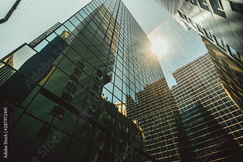 bulding new york - un ensemble de gratte-ciels modernes aux façades en verre réfléchissant la lumière du soleil, créant une vive éclatante. 