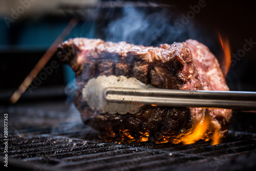 Grilled ancho steak on barbecue grill with fire. Barbecue ancho steak.