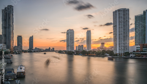Chao Phraya River with Skyscrapers at Sunset as Seen from Taksin Bridge in Bangkok, Thailand