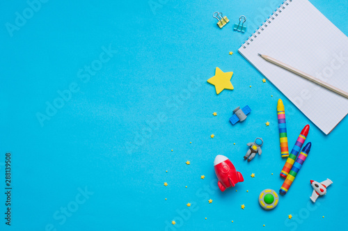 School accessories and space toys on blue background