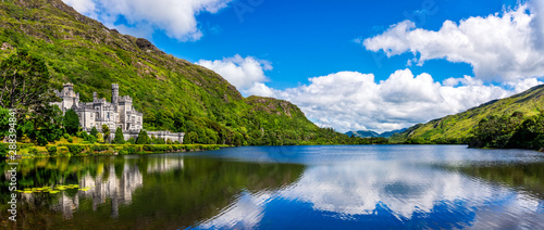 Panorama of Kylemore Abbey, beautiful castle like abbey reflected in lake at the foot of a mountain. Benedictine monastery, in Connemara, Ireland