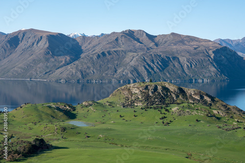 Looking down from the top of Roys Peak to agricultural farmland on the shores of Lake Wanaka New Zealand