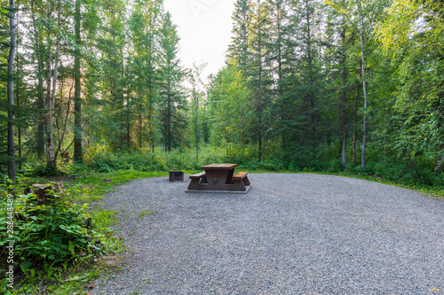 Empty campsite with picnic table in Liard River Hot Springs Provincial Park, British Columbia, Canada