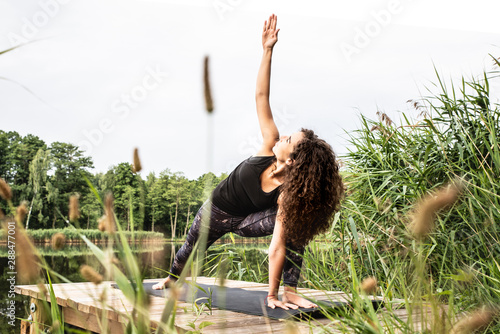 Kobieta ćwiczy jogę na tarasie. 