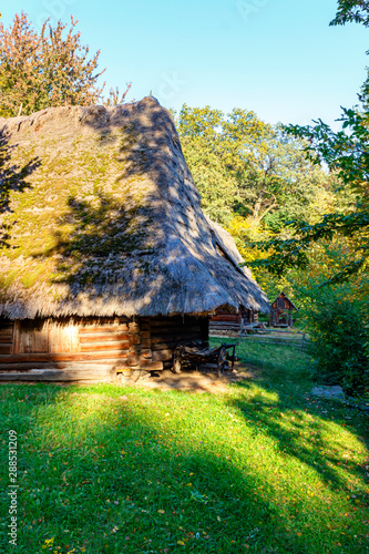 Old wooden house under thatched roof on a sunny summer day