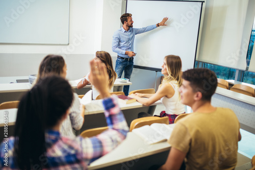 Young students listening to professor in the classroom on college