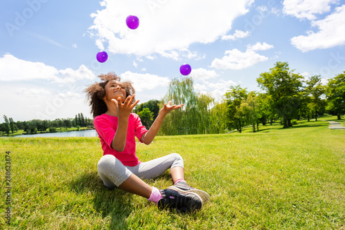 Little cute curly black beautiful girl juggle