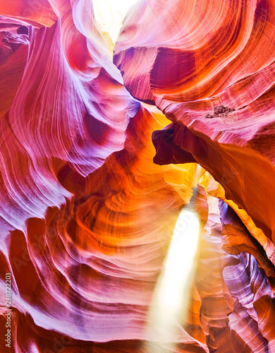 View of Upper Antelope Canyon with sunbeam shined into canyon at noon in early October in Arizona, USA.
