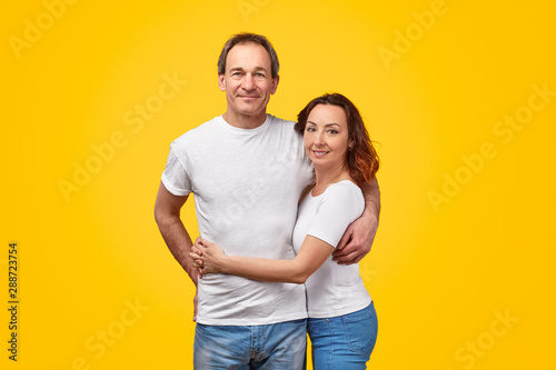 Adult couple hugging and looking at camera