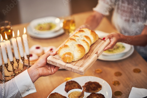 Hanukkah dinner. Family gathered around the table sharing challah