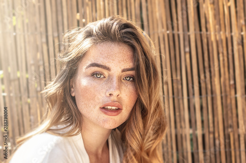 Portrait of young redhead woman with freckles.