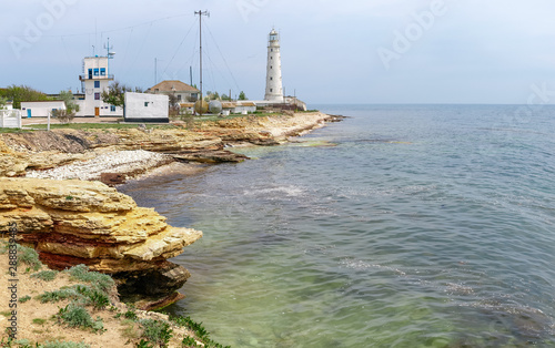 Old sea lighthouse on a low rocky limestone cape