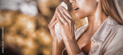 Beautiful woman using tissue while sneezing