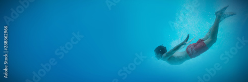 Young man swimming underwater