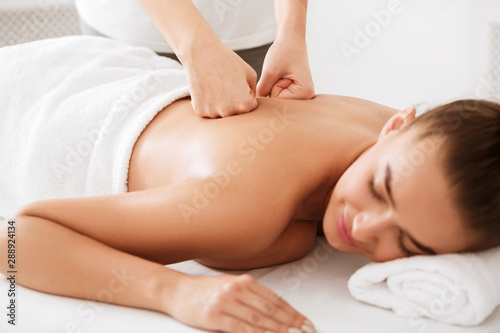 Body treatment. Girl getting back massage from physiotherapist