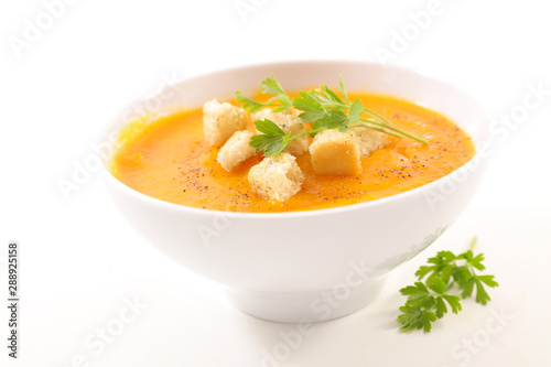 bowl of soup with crouton and parsley on white background