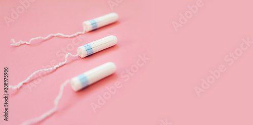 Menstrual tampon on a pink background. Menstruation time. Hygiene and protection for woman