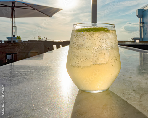 Rooftop view of sunset with a drink on the bar 