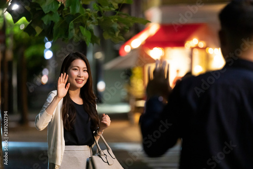 夜の繁華街で待ち合わせをする男女