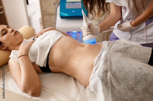 Hardware cosmetology. Body care. Spa treatment. Ultrasound cavitation body contouring treatment. Woman getting anti-cellulite and anti-fat therapy in beauty salon.