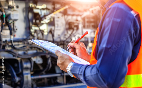 Preforming a pre-trip inspection on a truck,Concept preventive maintenance truck checklist,Check truck engine,Check the lubricating oil,spot focus.