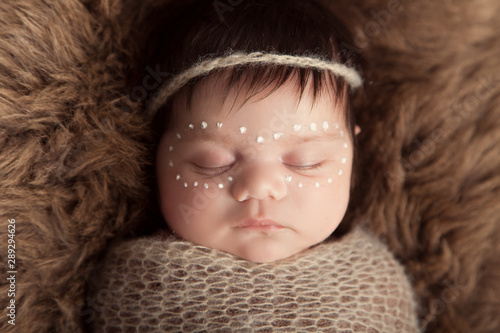 Newborn baby aboriginal girl, traditional facepaint.