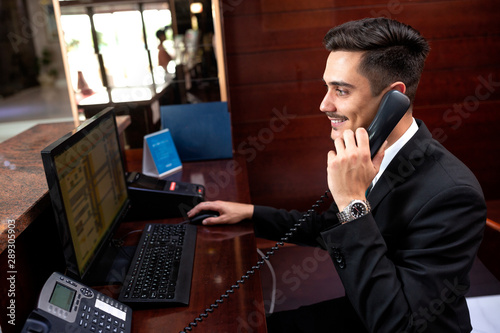 Elegantly dressed receptionist holding a headphone