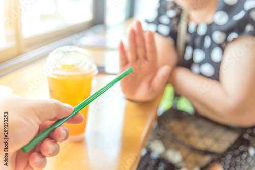 Close up hand holding straw and say no for plastic drinking straw. Concept related to banned plastic drinking straws, environmental concerns. x