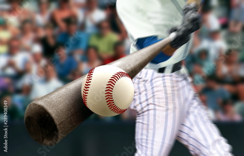 Baseball player hitting ball with bat in close up