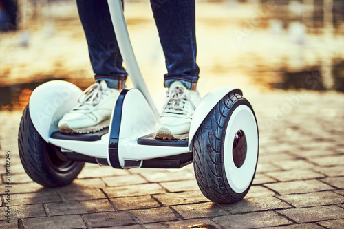 Human legs and feet on hoverboard park paths