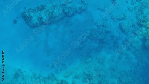 Water texture in ocean with corals. Blue sea water texture aerial drone view. Blue lagoon water surface