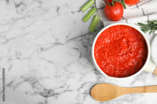 Flat lay composition with delicious tomato sauce on marble table. Space for text