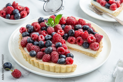 blueberry and raspberry tart on white marble background