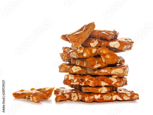 Stack of traditional peanut brittle candy pieces, isolated on a white background