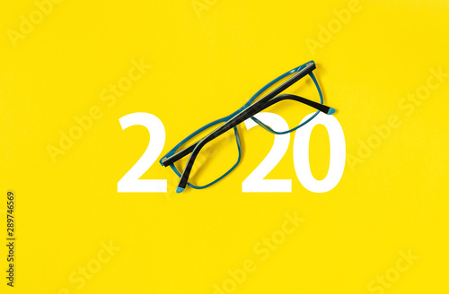 happy new year 2020. 2020 with glasses on yellow isolated background