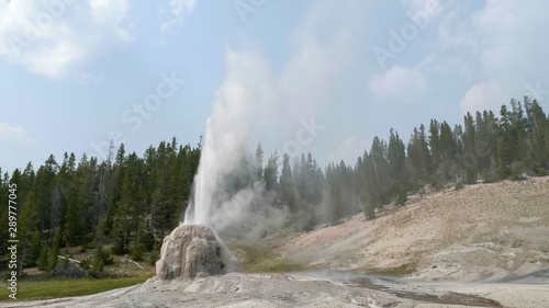 wide view of lone star geyser erupting in yellowstone