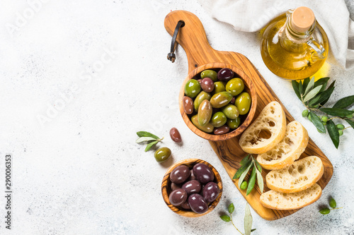 Olives, ciabatta and olive oil on white background.